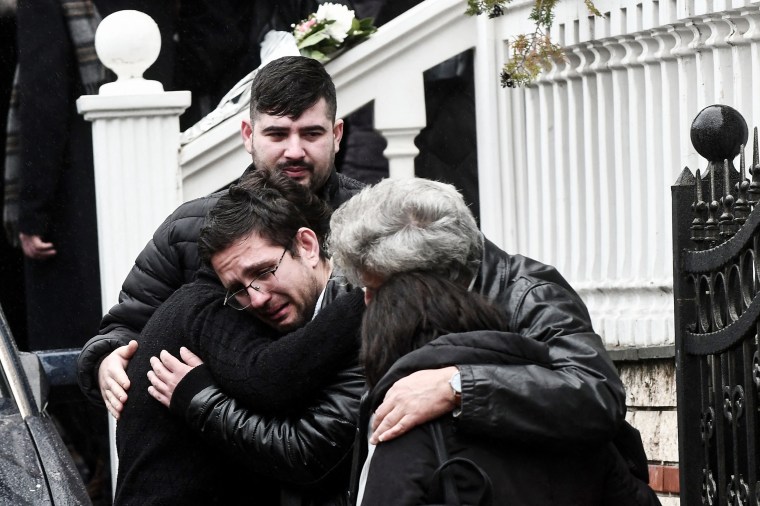 Mourners hug each other during the funeral of 23-year-old Ifigenia Mitska in Giannitsa, Greece, on March 4, 2023.