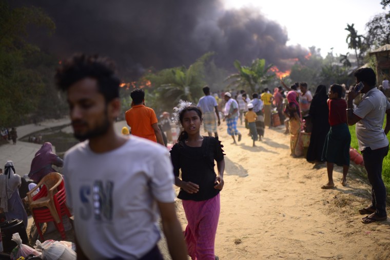 Rohingya refugees try to salvage their belongings after a major fire in their Balukhali camp at Ukhiya in Cox's Bazar district, Bangladesh, Sunday, March 5, 2023.