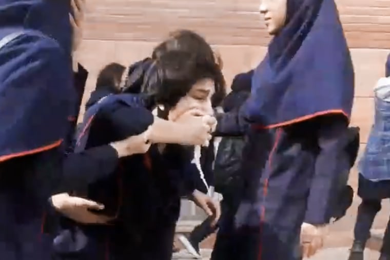 One video shows schoolgirls coughing in Nasimshahr, a city in northwest Iran, with one escorted outside and into an ambulance while  flanked by fellow students.