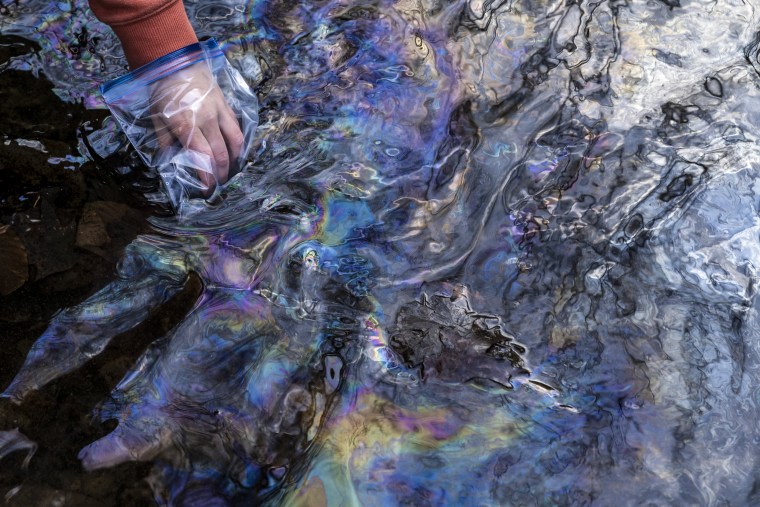 Image: Olivia Holley, 22, and Taylor Gulish, 22, collect water samples from Leslie Run Creek on February 25, 2023 in East Palestine, Ohio.  Holley and Gulish are testing the water for pH and total dissolved solids (TDS).