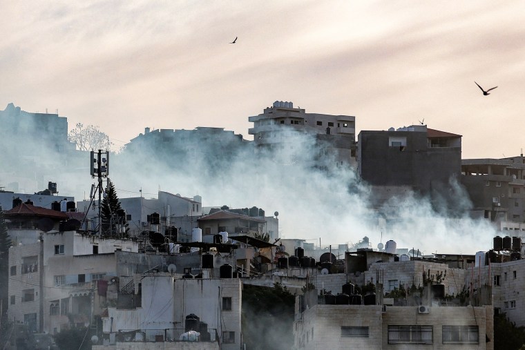 Birds fly as smoke plumes billow during an Israeli army raid in the Jenin camp for Palestinian refugees in the occupied West Bank on March 7, 2023. - Israeli troops killed six Palestinians in Jenin on March 7, including an alleged militant accused of killing two Israelis. The Palestinian health ministry said six men had been killed, one aged 49 and the rest in their 20s, in clashes that the army said included soldiers launching shoulder-fired rockets amid ferocious gunfire.