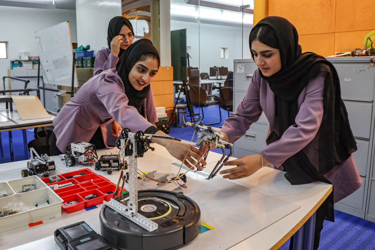 ريحانة ستاري ، من اليسار ، مروة شينواري وهيلا باراكزاي ، أعضاء فريق الروبوتات المكون من فتيات فقط ، يجمعن المكونات في العاصمة القطرية الدوحة.