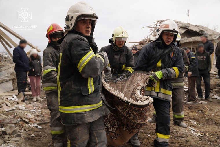 Rescue workers carry the body of a man killed after a rocket attack in Lviv on Thursday. 