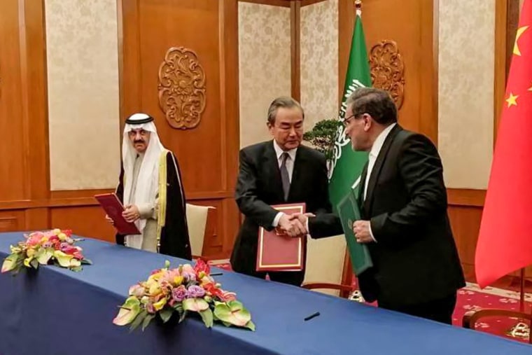The secretary of the Supreme National Security Council of Iran, Ali Shamkhani, right, shakes hands with the Director of the Office of the Central Foreign Affairs Commission of the Chinese Communist Party Wang Yi during a meeting with Saudi Arabia's National Security adviser and Minister of State Musaad bin Mohammed al-Aiban in Beijing on March 10, 2023.
