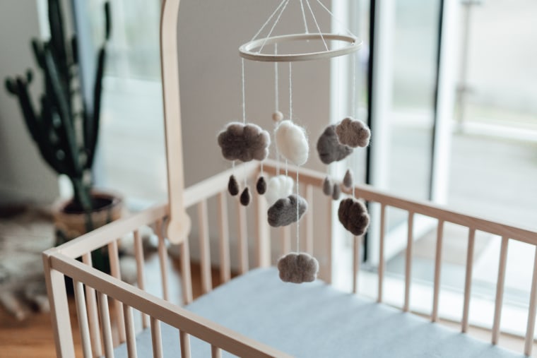 A mobile hangs over a crib.