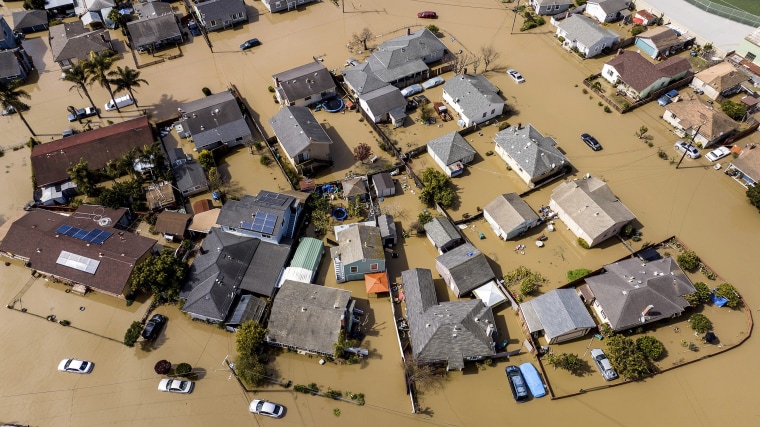 El agua de la inundación rodea casas y vehículos en el condado de Monterey, California.