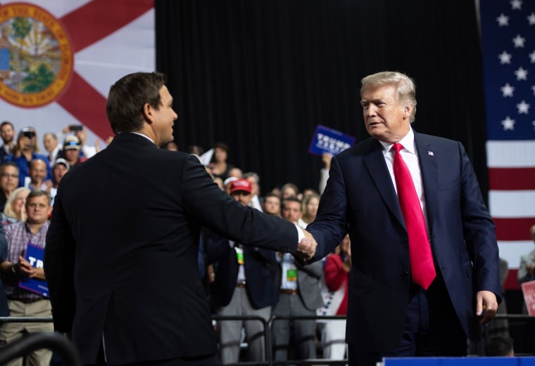 Then-President Donald Trump shakes hands with then-Rep. Ron DeSantis at a campaign rally in Tampa, Fla.