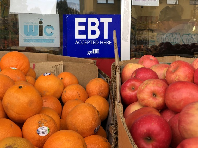 EBT sign over oranges and apples for sale.