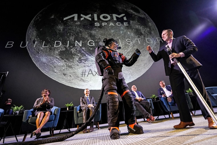 Image: Axiom Space chief engineer Jim Stein, left, bumps fists with deputy manager for extravehicular activity Russell Ralston while demonstrating a prototype spacesuit on March 15, 2023, in Houston. 