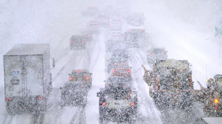 Plows, at right, try to pass nearly stopped traffic, due to weather conditions, on Route 93 South, in Londonderry, N.H.