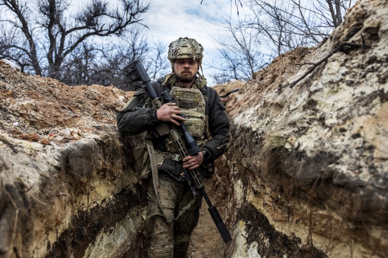 A Ukrainian sniper moves to a fighting position in a frontline trench outside of Bakhmut, Ukraine