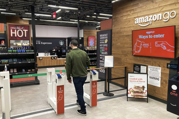 A man uses his smartphone to enter an Amazon Go convenience store in New York