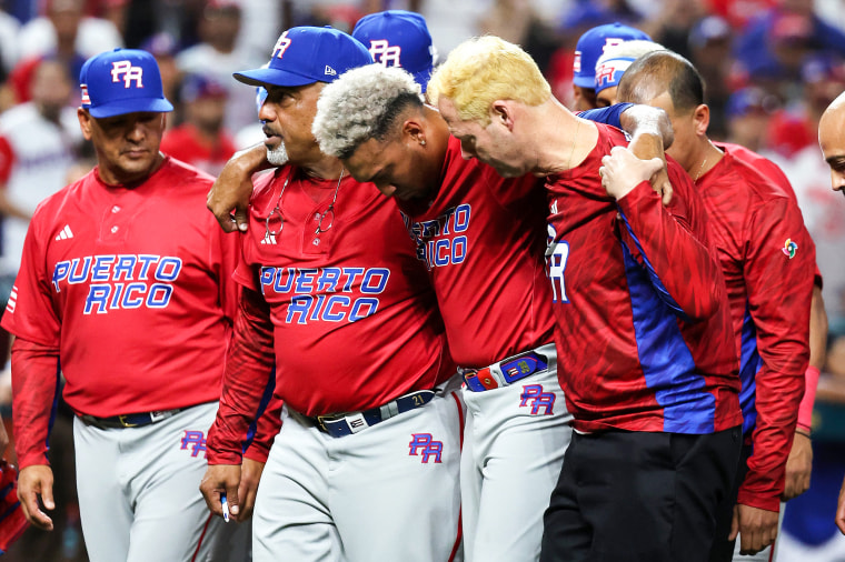 Edwin Diaz of Puerto Rico is helped off the field after being injured during the on-field celebration after defeating the Dominican Republic during the World Baseball Classic Pool D on March 15, 2023, in Miami.