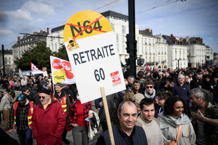 Protestors hold a sign reading " Retirement 60" during a demonstration against the government's proposed pensions overhaul, in Nantes, France