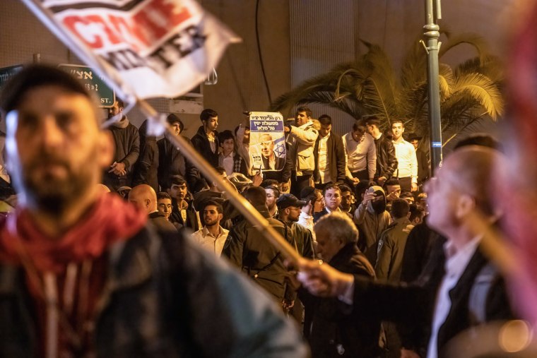 Orthodox youths hold a banner with Prime Minister Benjamin