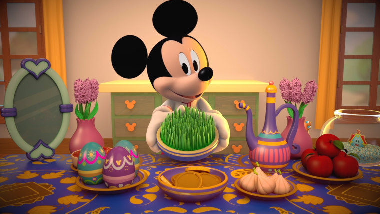 Mickey Mouse displaying his “haftseen,” a traditional table put together for the Persian New Year