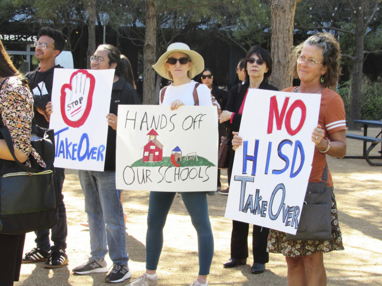 People protest the proposed state takeover of Houston public schools during a news conference