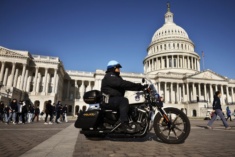 A U.S. Capitol Police officer drives his motorcycle across the East Front Plaza as tourists visit the Capitol building on March 20, 2023 in Washington, DC. The security posture in Washington appeared normal on Monday after former President Donald Trump called for protests after he announced on social media that he expected to be arrested this week and charged with breaking campaign finance laws for paying an adult film star hush money during the 2016 presidential election.