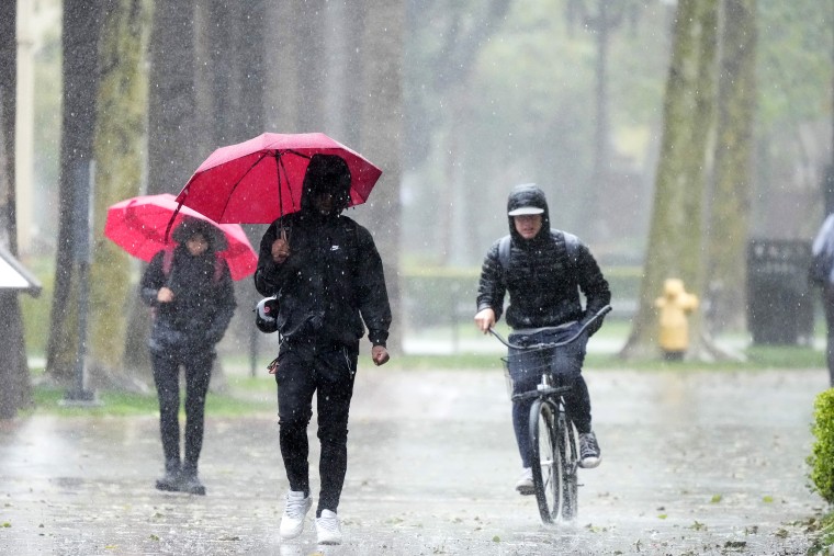 Rain falls on pedestrians on the University of Southern California campus on Tuesday, March 21, 2023, in Los Angeles.