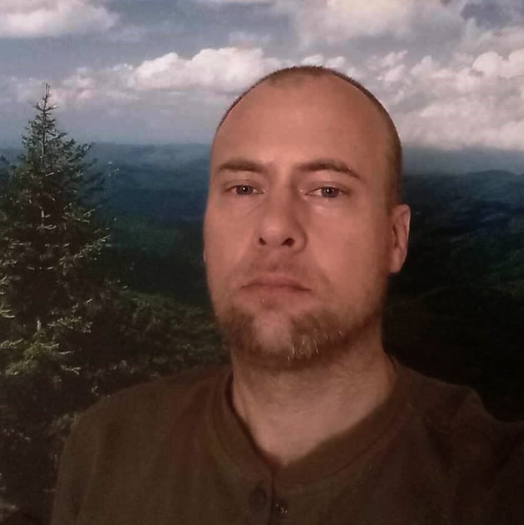 Selfie of U.S. Navy veteran, Travis Zubick, in front of a forest landscape.