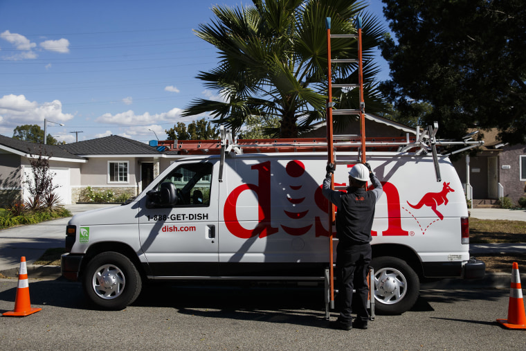 A Dish Network Corp. field service specialist carries a ladder after installing a satellite television system at a residence in Paramount, Calif.