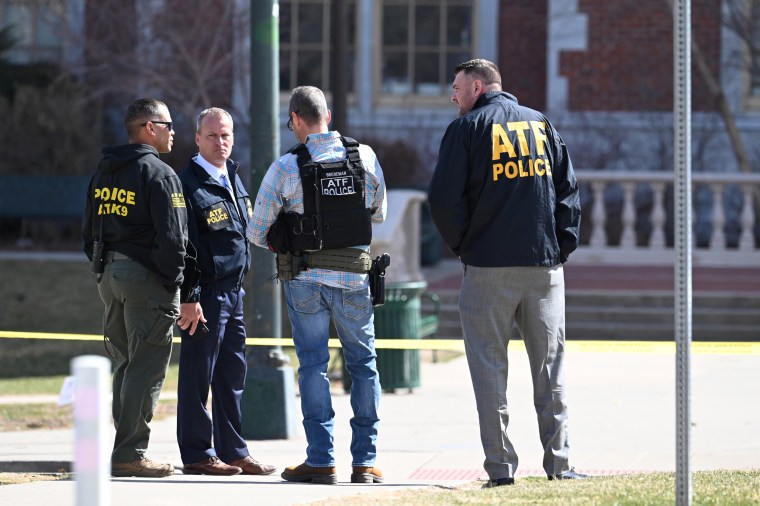 Law enforcement investigate the crime scene at East High School in Denver