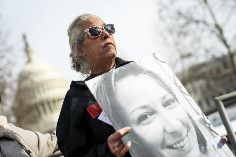 Micki Witthoeft holds a photograph of her late daughter Ashli Babbitt during a protest at the Capitol