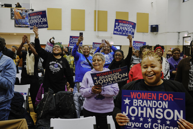 People hold signs and cheer during a "Women for Brandon" event in Chicago