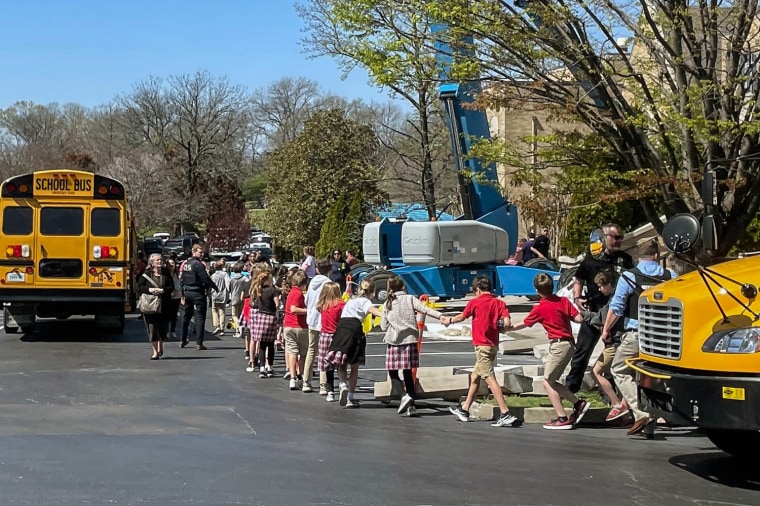 Image: Children from The Covenant School, a private Christian school in Nashville, Tenn., hold hands as they are taken to a reunification site at the Woodmont Baptist Church after a shooting at their school, on March, 27, 2023.