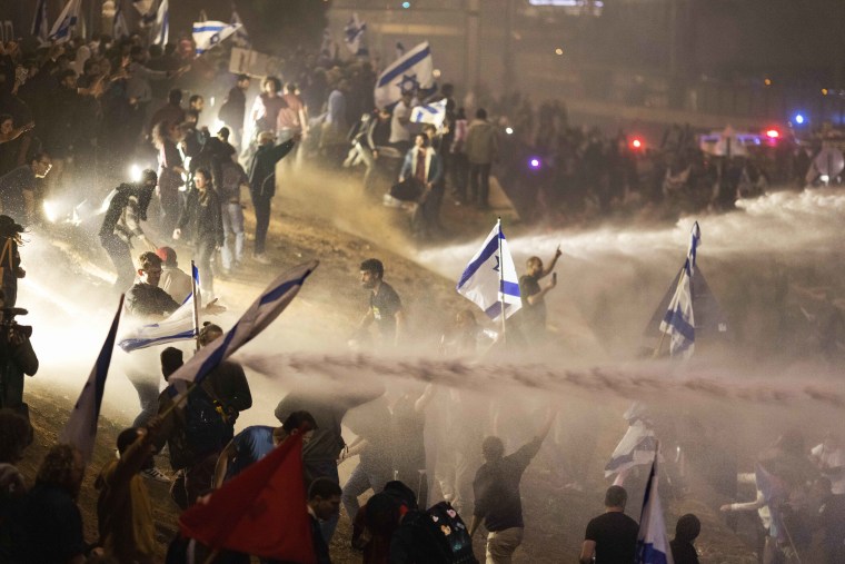 Tens of thousands of Israelis have poured into the streets across the country in a spontaneous outburst of anger after Prime Minister Benjamin Netanyahu abruptly fired his defense minister for challenging the Israeli leader's judicial overhaul plan.