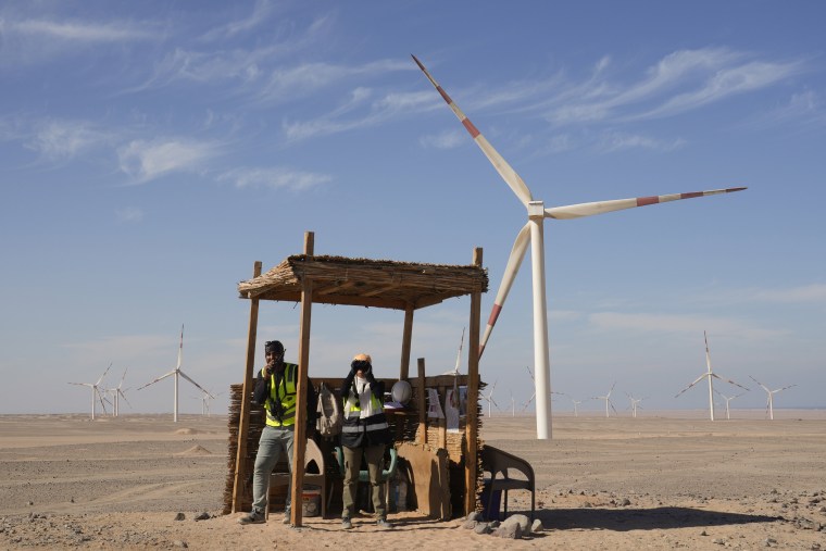 Bird watchers Omima Sayed, right, and Amr Abdel Hady look out at the the sky while at Lekela wind power station, near the Red Sea city of Ras Ghareb, Egypt