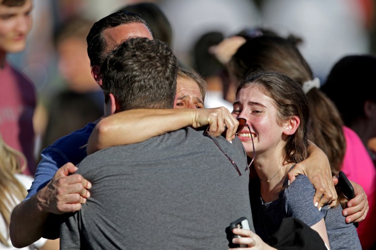 A family hugs as they reunites outside of Stoneman Douglas High School after a shooting