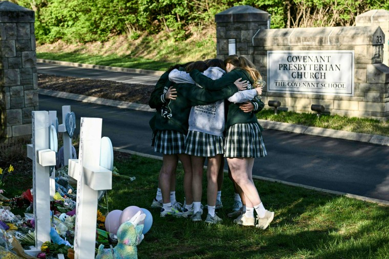 Girls embrace in front of a makeshift memorial for victims by The Covenant School in Nashville on March 29, 2023.