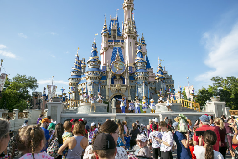 People watch mascots perform onstage in front of Cinderella's castle at Walt Disney World Resort.