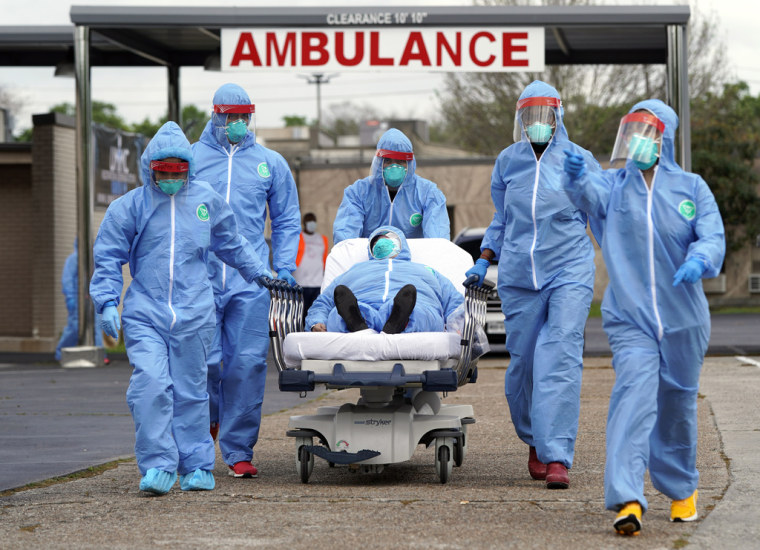 Una persona es trasladada en camilla al United Memorial Medical Center tras someterse a las pruebas del COVID-19 el jueves 19 de marzo de 2020, en Houston, Texas.