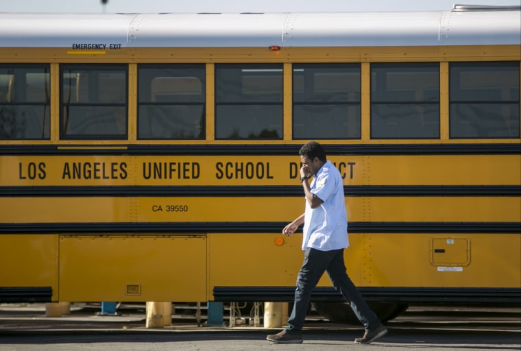 Un conductor camina frente un autobús del Distrito Escolar Unificado de Los Ángeles en la ciudad de Gardena, California, en una imagen tomada el 15 de diciembre de 2015.
