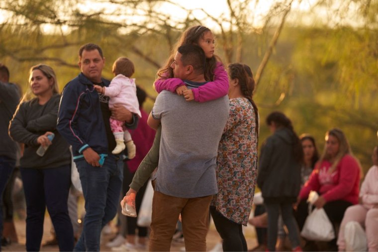 Un padre sostiene a su hija mientras esperan en la frontera con México en una foto de archivo de octubre de 2022.