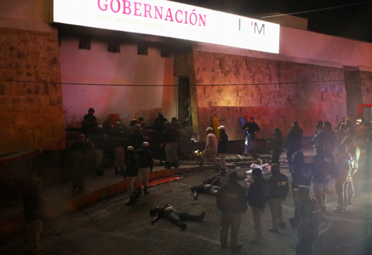 Bomberos y policías rescatan a migrantes de una estación migratoria en Ciudad Juárez, estado de Chihuahua, el 27 de marzo de 2023, donde al menos 39 personas murieron y decenas resultaron heridas tras un incendio en la estación migratoria.