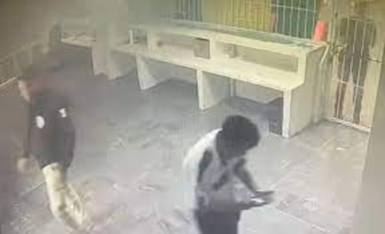 Personal del centro de migrantes de Ciudad Juárez, Chihuahua, pasan frente a la celda donde se encontraban 68 hombres mientras se desata un incendio allí dentro, el 27 de marzo de 2023.