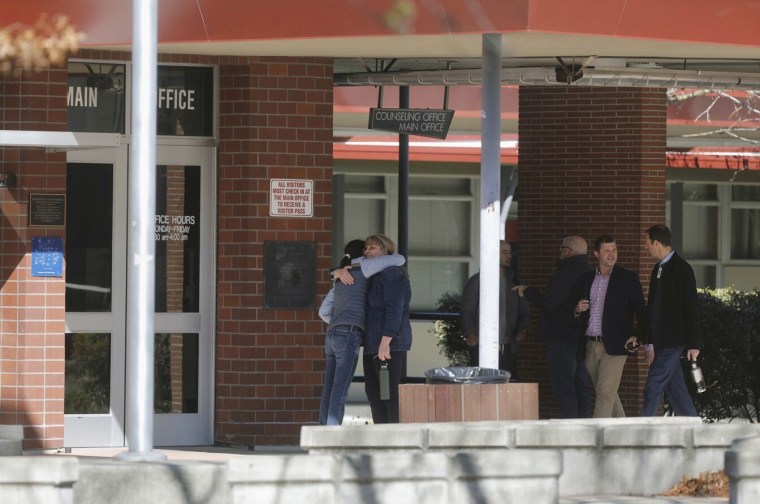 People gather outside the main office after students were released for the day following a fight at Montgomery High School in Santa Rosa, Calif., Wednesday, March 1, 2023. Authorities said a 16-year-old student involved in the fight was fatally stabbed Wednesday inside a classroom full of students.