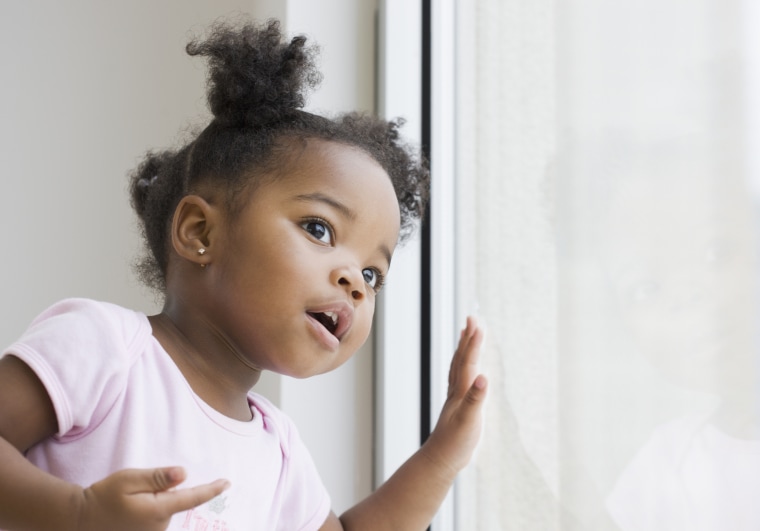 African American girl looking out window
