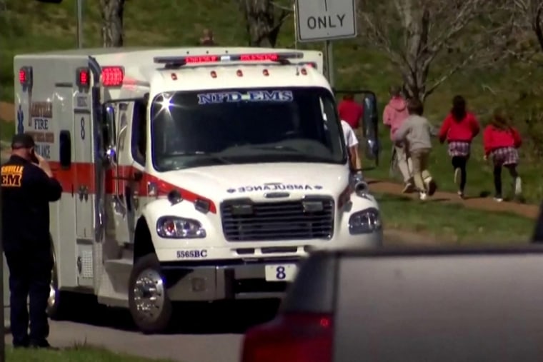 Los niños pasan corriendo junto a una ambulancia cerca de la Escuela Covenant después de un tiroteo en Nashville, Tennessee.
