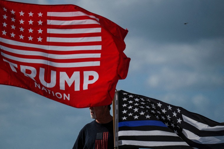Un partidario del expresidente sostiene una bandera cerca de Mar-a-Lago, Florida. 