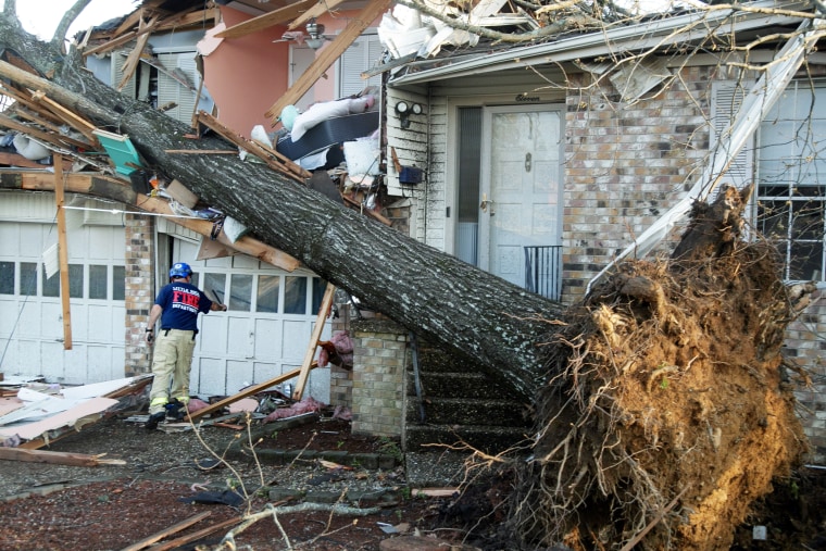 A firefighter checks homes for injured residents in Little Rock, Ark.