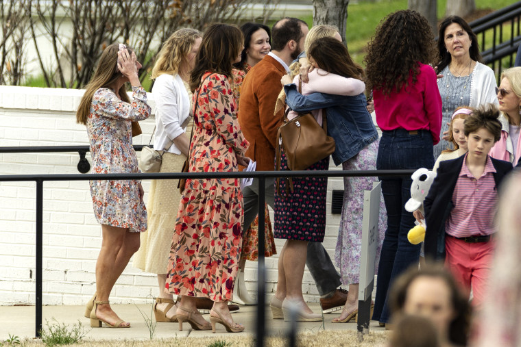 Los dolientes se abrazan después del funeral de Evelyn Dieckhaus en Nashville, Tennessee.