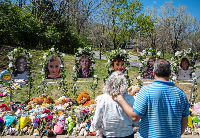 People visit a memorial for the shooting victims at the entrance of The Covenant School