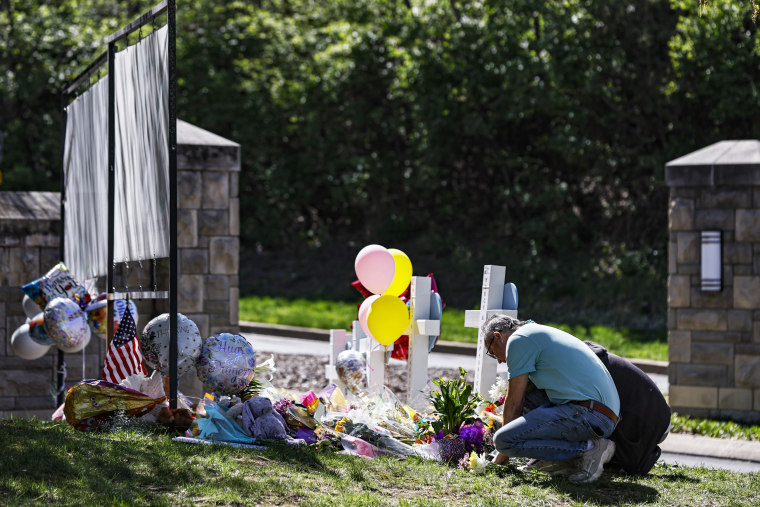 People pray at a memorial at the entrance to the Covenant School in Nashville, Tenn.