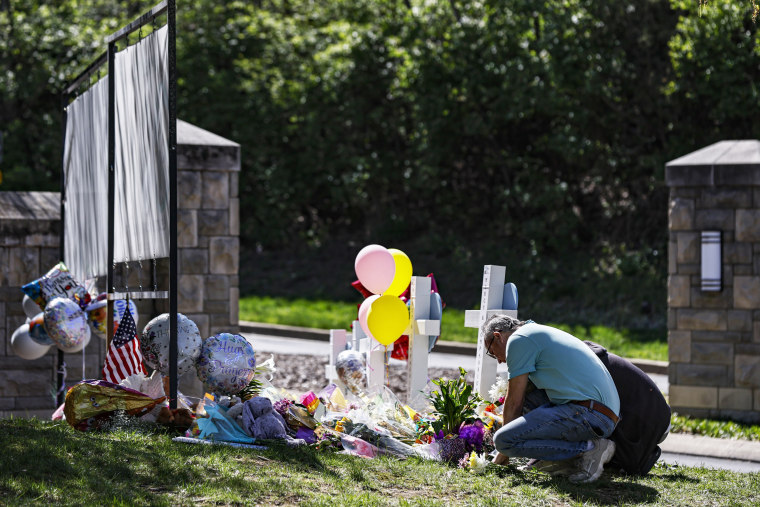 People pray at a monument at the entrance to the Covenant School in Nashville, Tennessee.