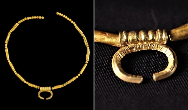 A gold necklace with a crescent moon shape, which would have been positioned on or near the body to protect the spirit in the world to come.