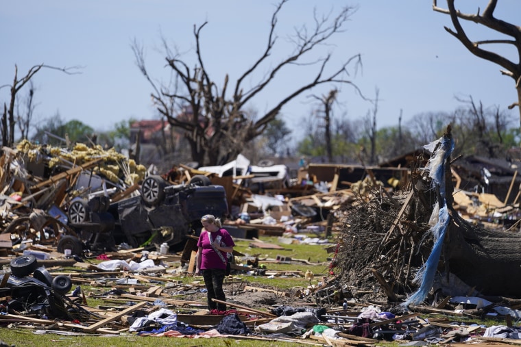 A woman walks through tornado damage in Rolling Fork, Miss